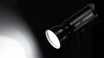 Мережевий студійний моноблок Godox QT600III зі стандартним рефлектором у темному павільйоні з увімкненим пілотним LED-світлом
